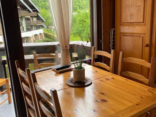 une table en bois avec une plante en pot au-dessus dans l'établissement Charmant appartement 2 pièces avec WiFi et parking - FR-1-629-27, à Samoëns