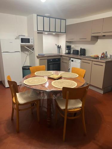 une cuisine avec une table en bois et des chaises et une cuisine avec des appareils blancs dans l'établissement Maison de ville rénovée, à Senonches