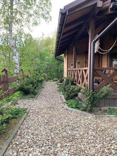 a house with a gravel path next to a building at Domek Letniskowy Zielone Tarasy z Sauną i Jacuzzi in Korczyna