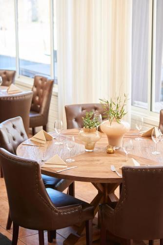 a dining room with a wooden table and chairs at Hotell Björkhaga in Mullsjö
