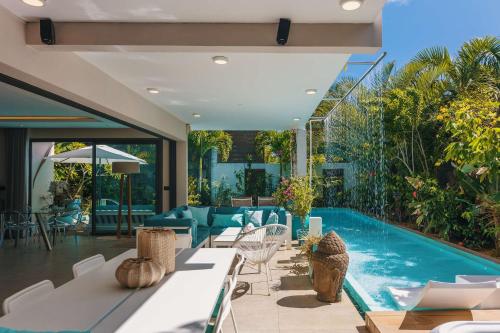 an outdoor patio with a swimming pool and a house at Villa Ayana - Premium Mauritius Stay in Grand Baie
