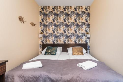 a bedroom with a bed with a headboard and pillows at Lazurowy Dwór - Królewski Sen by Grand Apartments in Sztutowo