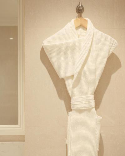 a white dress on a hanger on a wall at Palace Hotel & SPA in Durrës