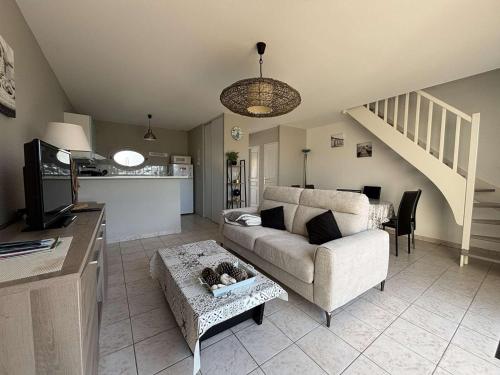 un salon avec un canapé et une table dans l'établissement Maison Moderne Proche Port La Cotinière – 4 Pers, Jardin, Terrasse, Plages à Proximité - FR-1-246A-109, à Saint-Pierre-dʼOléron