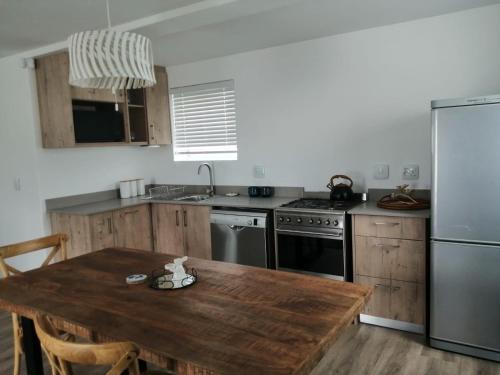 a kitchen with a wooden table and a refrigerator at Skye in Paternoster