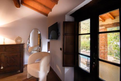 a room with a mirror and a chair and a window at Il Mulino di Nonna Sà - Prestige Private Villa in Pietrasanta