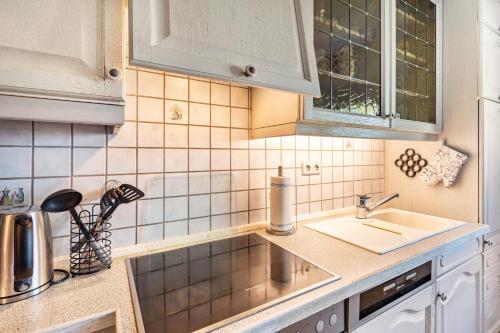 a kitchen with white cabinets and a sink at Haus Waldesruh in Medebach