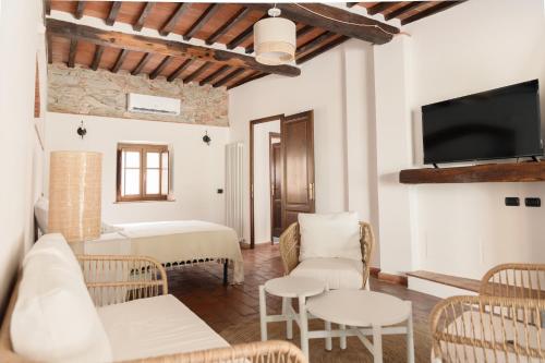 a living room with a bed and a tv at Il Mulino di Nonna Sà - Prestige Private Villa in Pietrasanta