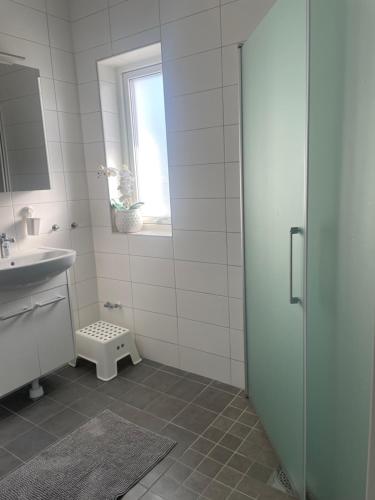 a white bathroom with a shower and a sink at villa near Åda golf in Trosa