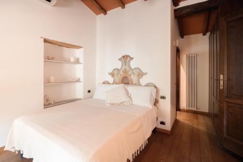 a bedroom with a white bed with a wooden headboard at Il Mulino di Nonna Sà - Prestige Private Villa in Pietrasanta