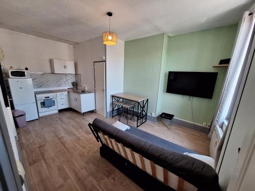 un salon avec un canapé et une télévision à écran plat dans l'établissement Appartement 2eme étage, à Saint-Dizier