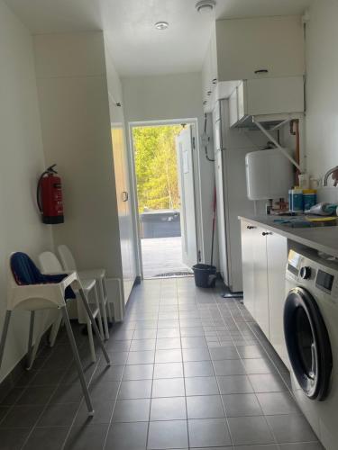 a kitchen with a table and chairs and a door at villa near Åda golf in Trosa