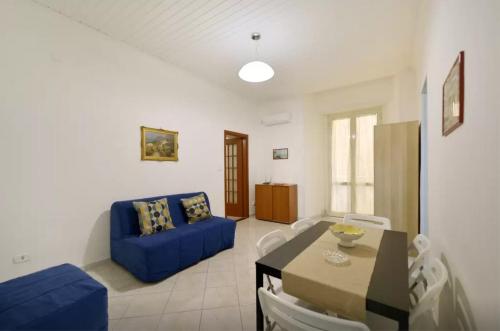 a living room with a blue couch and a table at Trimarchi House in Naples