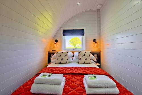 a bedroom with a bed with two towels on it at Hollins Farm - Dog Friendly, Self Catering Holiday Lodges in Knaresborough
