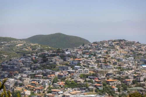 an aerial view of a city on a hill at בקתות עץ מעל העננים - אירוח דרוזי - בקתות כפריות עם נוף מהמם ובריכה משותפת in Bet Dagan