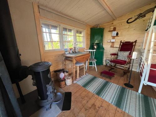 a room with a stove and a table in a room at Naturnära Fritidsboende, Trollebo - YinTorp in Arkelstorp