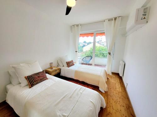 une chambre avec deux lits et une fenêtre dans l'établissement Center of Antibes, Les Amaryllis - 3 Rooms, 5 minutes from the beaches, à Antibes