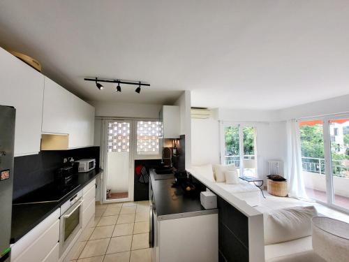- une cuisine avec des murs blancs et des comptoirs noirs dans l'établissement Center of Antibes, Les Amaryllis - 3 Rooms, 5 minutes from the beaches, à Antibes