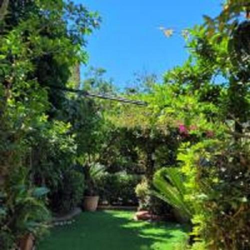 a garden with green grass and trees and bushes at Le Sale Resort in Caserta