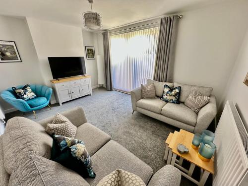 a living room with two couches and a tv at Beautifully Spacious 3 Bed Home in Kenton