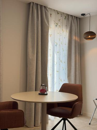 a table and chairs in a room with a window at Hôtel confidentiel Le Grecale in Pianottoli-Caldarello