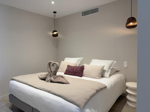 a white bedroom with a white bed with pillows at Hôtel confidentiel Le Grecale in Pianottoli-Caldarello