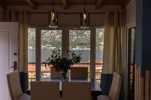 a dining room with a table and a large window at Full Sea View Penthouse with Panoramic terrace in Prčanj