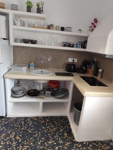 a white kitchen with a sink and a counter at suite diminutif l in Adamas