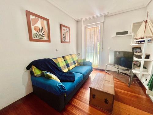 a living room with a blue couch and a coffee table at Circobueno de Isla - 5609 in Arnuero