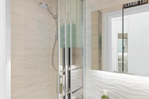 a shower with a glass door next to a mirror at Chic 1-Bed Hideaway in Hockley in Nottingham
