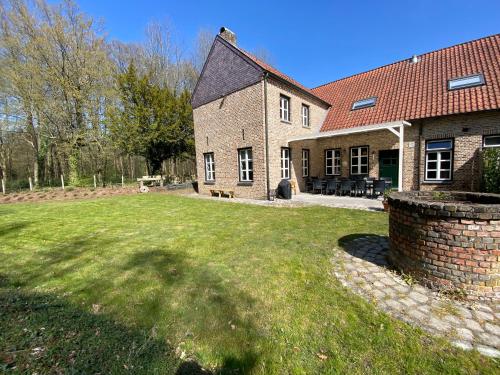 a large brick house with a lawn in front of it at Landgoed De Hoogmolen in Oudsbergen 