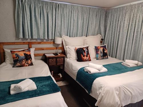 a bedroom with two beds with pillows on them at Orchard Guesthouse in Bloemfontein