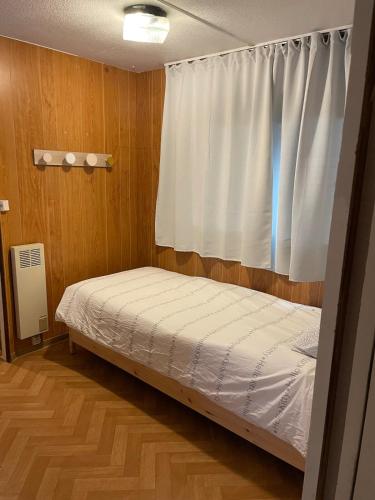 une petite chambre avec un lit et une fenêtre dans l'établissement La Cabane, à Cruzilles-lès-Mépillat