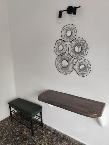 a bench and a chair in a room with a wall at suite diminutif l in Adamas