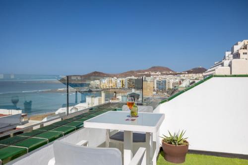 a white table on a balcony with a view of the ocean at Exe Las Palmas in Las Palmas de Gran Canaria