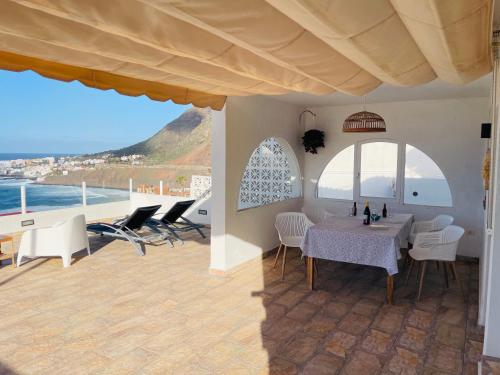 巴哈马尔Relax View的一间有桌子、椅子和大海的餐厅