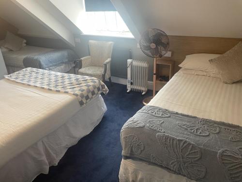 a attic bedroom with two beds and a chair at Diamonds Inn in York