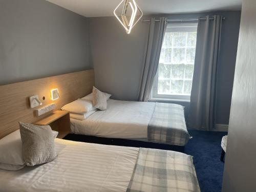 a hotel room with two beds and a window at Diamonds Inn in York