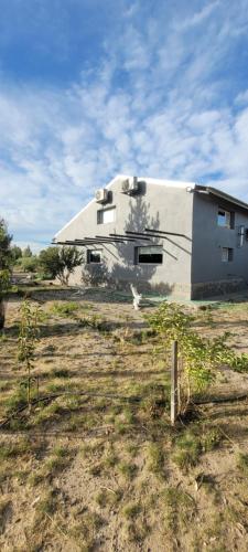 un edificio blanco en medio de un campo en Finca san benito, en Puerto Madryn
