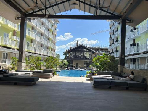 Lapu Lapu CityCozy & Convenient 1-Bedroom Condo 3 mins Away from the Airport的带沙发的庭院和大楼内的游泳池