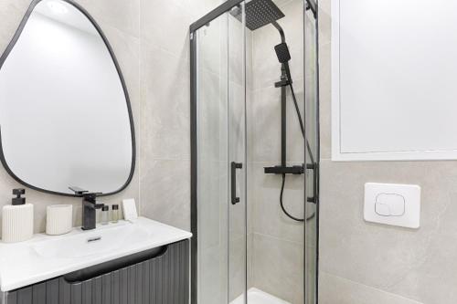 une salle de bain avec une douche avec un lavabo et un miroir dans l'établissement CIA - Lovely Studio East Paris, à Paris