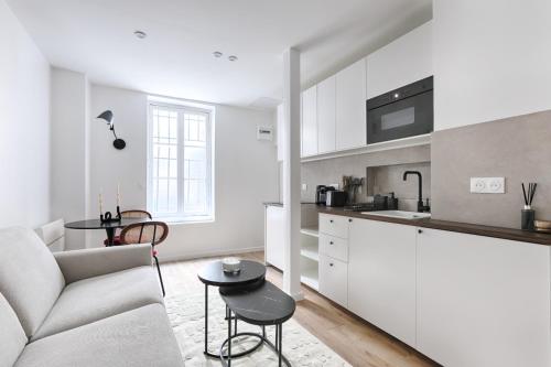 une cuisine et un salon avec un canapé et une table dans l'établissement CIA - Lovely Studio East Paris, à Paris