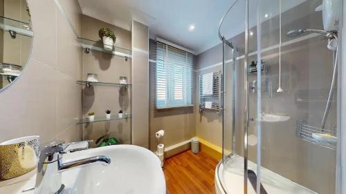 a bathroom with a shower and a sink at Marina View Apartment in Swansea