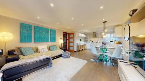 a living room with a couch and a kitchen at Marina View Apartment in Swansea