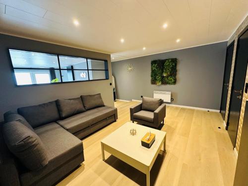 a living room with a couch and a table at Le Studio by Home Concept in Warisoulx