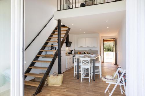 Un escalier mène à la cuisine et à la salle à manger d'une maison. dans l'établissement Les Marines T3 vue mer St-Florent, à Saint-Florent