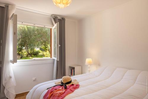 - une chambre dotée d'un grand lit avec un chapeau dans l'établissement Les Marines T3 vue mer St-Florent, à Saint-Florent