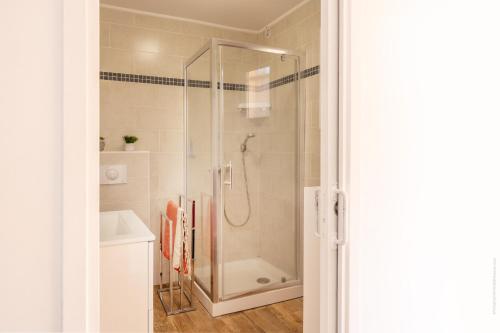 une douche avec une porte vitrée dans une salle de bain dans l'établissement Les Marines T3 vue mer St-Florent, à Saint-Florent
