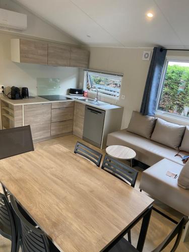 une cuisine et un salon avec une table et un canapé dans l'établissement Bungalow Toscane 3 chambres, à La Teste-de-Buch