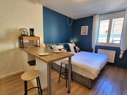 une chambre avec un lit et une table avec des chaises dans l'établissement Les Loges du Beffroi - L'azur, à Arras